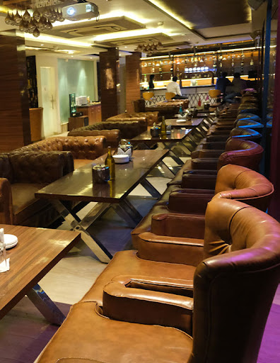 Hotel Naveen Continental Prayagraj [Modern Restaurant Interior At Hotel Naveen Continental With Stylish Columns And Ambient Lighting.]